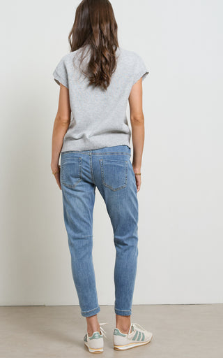Woman wearing a blue jogger jeans with elasticated wait and drawstring standing against a white background