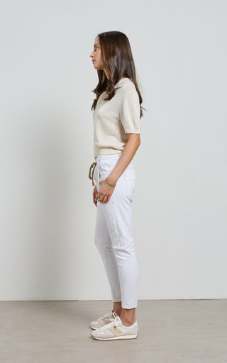 Woman wearing a White jogger jeans with elasticated wait and drawstring standing against a white background