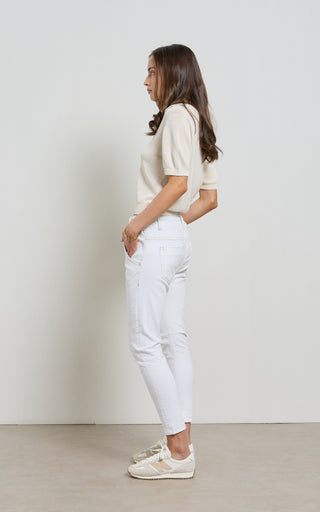 Woman wearing a White jogger jeans with elasticated wait and drawstring standing against a white background