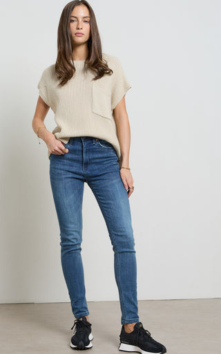 Woman wearing a Mid Blue Skinny Jeans standing against a white background