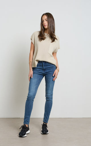 Woman wearing a Mid Blue Skinny Jeans standing against a white background