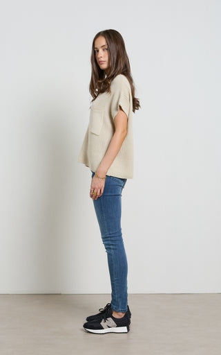 Woman wearing a Mid Blue Skinny Jeans standing against a white background