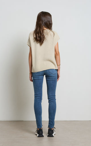 Woman wearing a Mid Blue Skinny Jeans standing against a white background