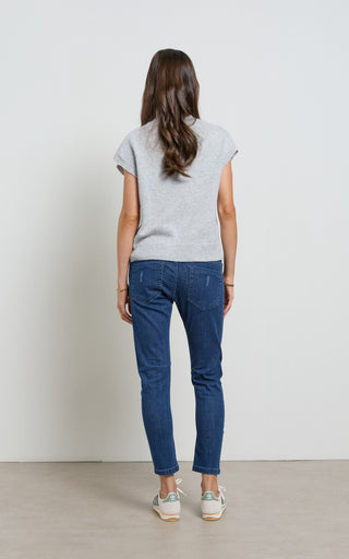 Woman wearing a Dark Denim jogger jeans with elasticated wait and drawstring standing against a white background