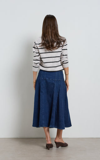 Women wearing a midi denim skirt with front button opening.