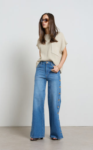 Woman wearing a wide leg jeans with horn button opening on the outer seam