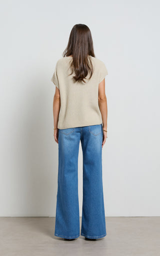 Woman wearing a wide leg jeans with horn button opening on the outer seam