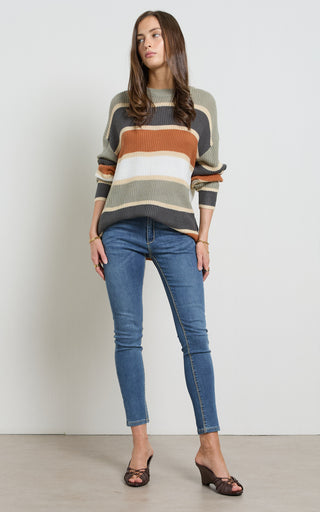 Woman wearing a Mid blue stretch denim skinny jeans standing against a white background