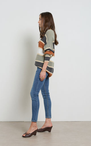 Woman wearing a Mid blue stretch denim skinny jeans standing against a white background