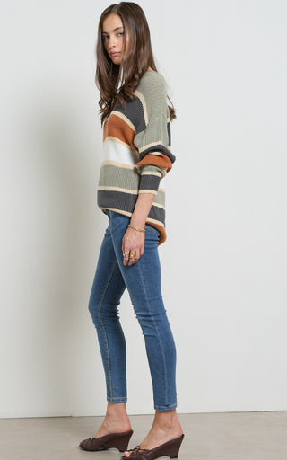 Woman wearing a Mid blue stretch denim skinny jeans standing against a white background